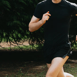 a man running in a park with trees in the background